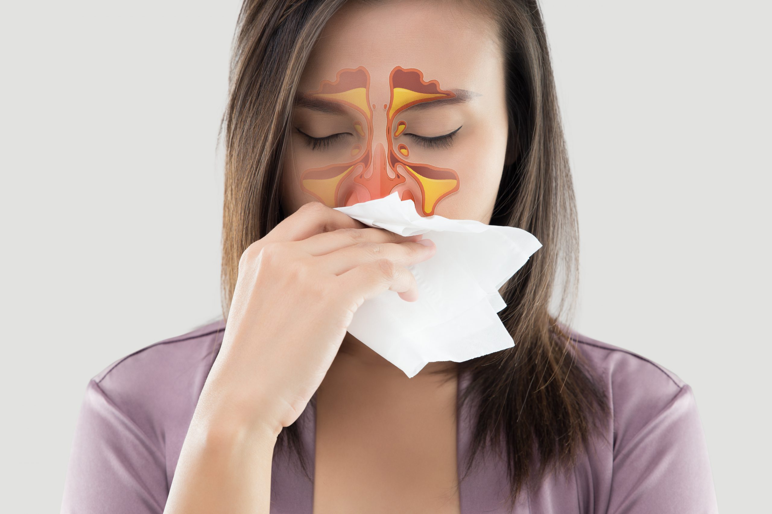 Woman with Sinusitis holding a tissue
